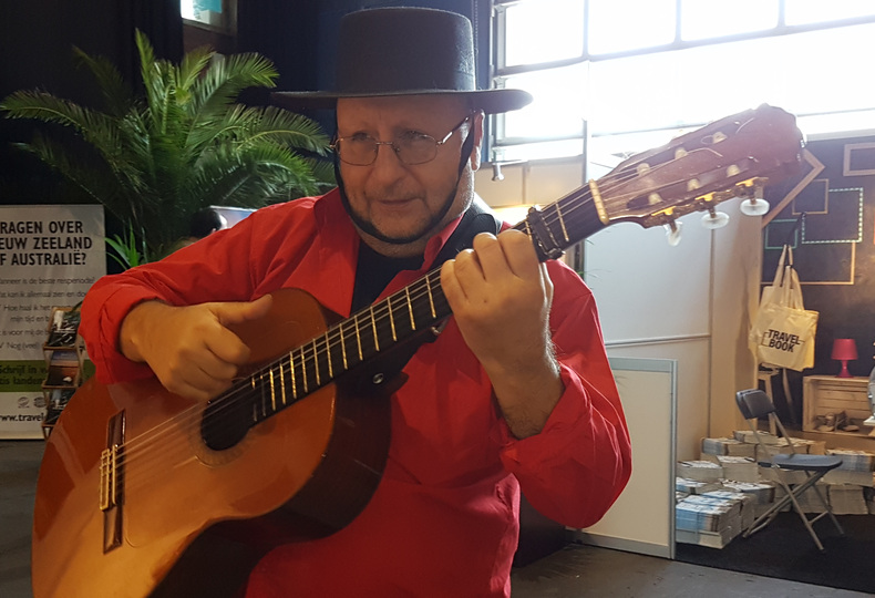 Gitarist in rode blouse tijdens het spelen