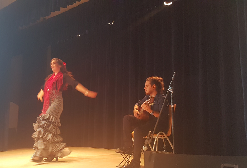 Flamencodanseres met begeleidende gitarist op het podium