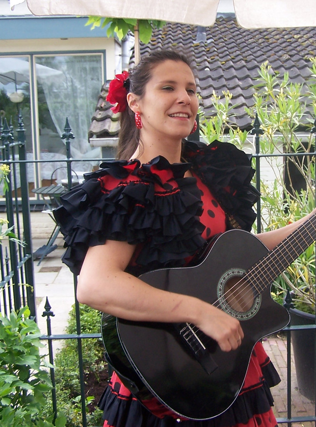 Artiest met gitaar en rood-zwarte Spaanse jurk